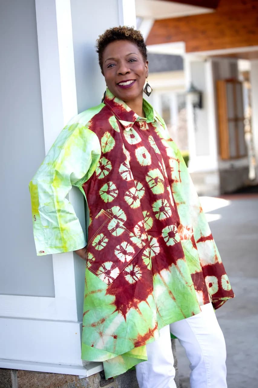 Dr. TLC smiling in a vibrant tie-dye tunic
